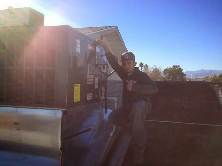 HVAC technician performing Air Duct Repair on a rooftop unit in DeLand